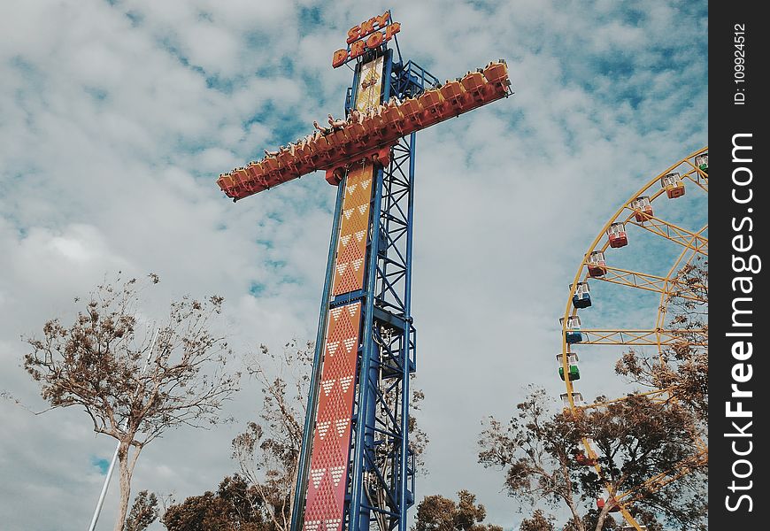People Riding on Amusement Park Blue and Orange Sky Drop