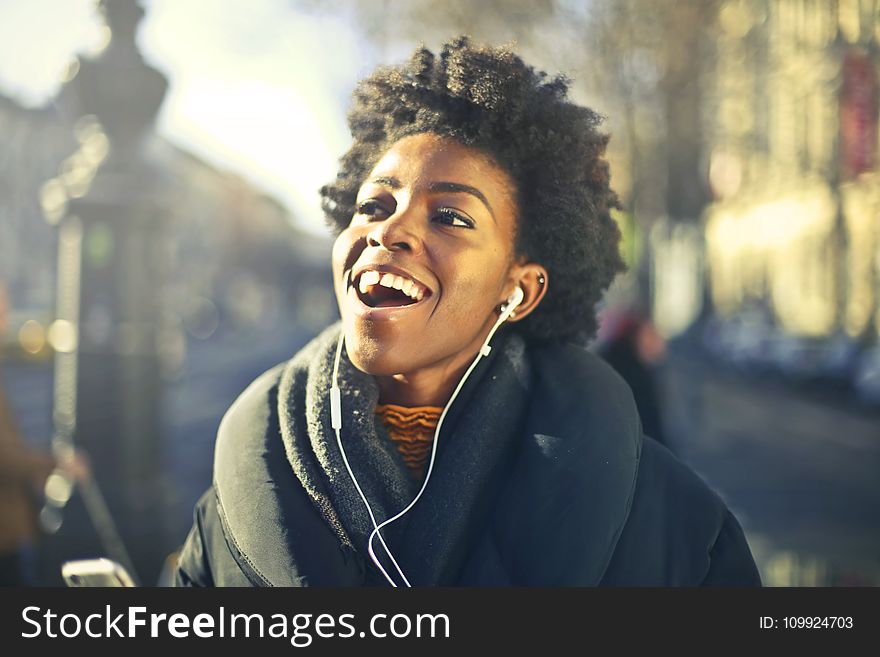 Close-up Photo of a Woman Listening to Music