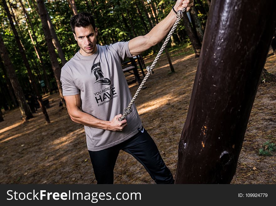 Photo of Man in Gray Shirt Holding Brown Rope