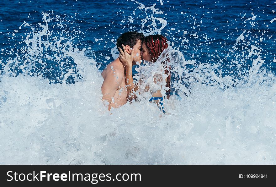 Couple Kissing While Waves Crash