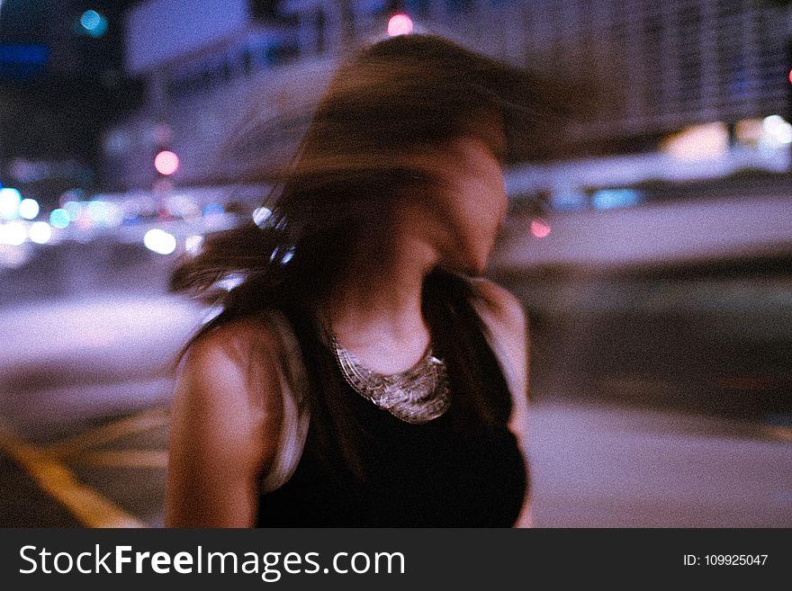 Tilt Shift Photography Of Woman Wearing Tank Top During Nighttime