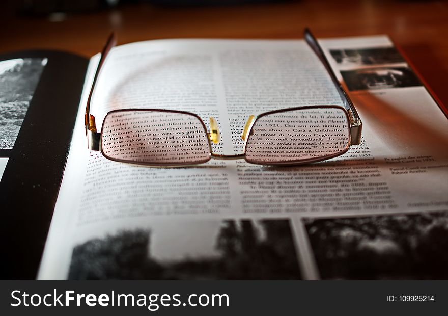 Eyeglasses With Gold-colored Frame on Opened Book