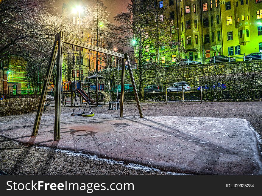 Playground Surrounded With Buildings And Cars