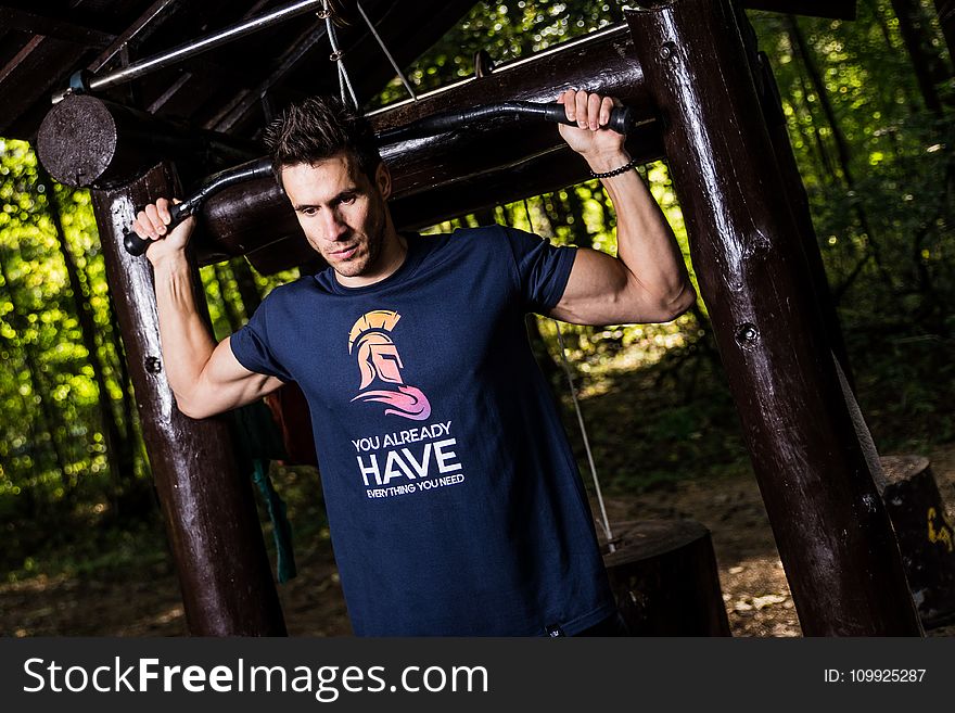 Man Wearing Blue Shirt Using Gym Equipments