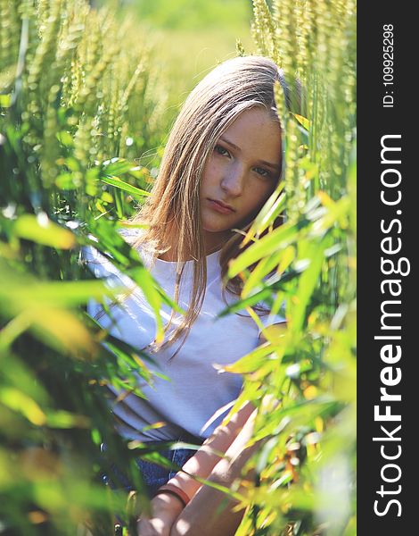 Selective Focus Photo of Woman Wearing White Shirt Between Green Wheat