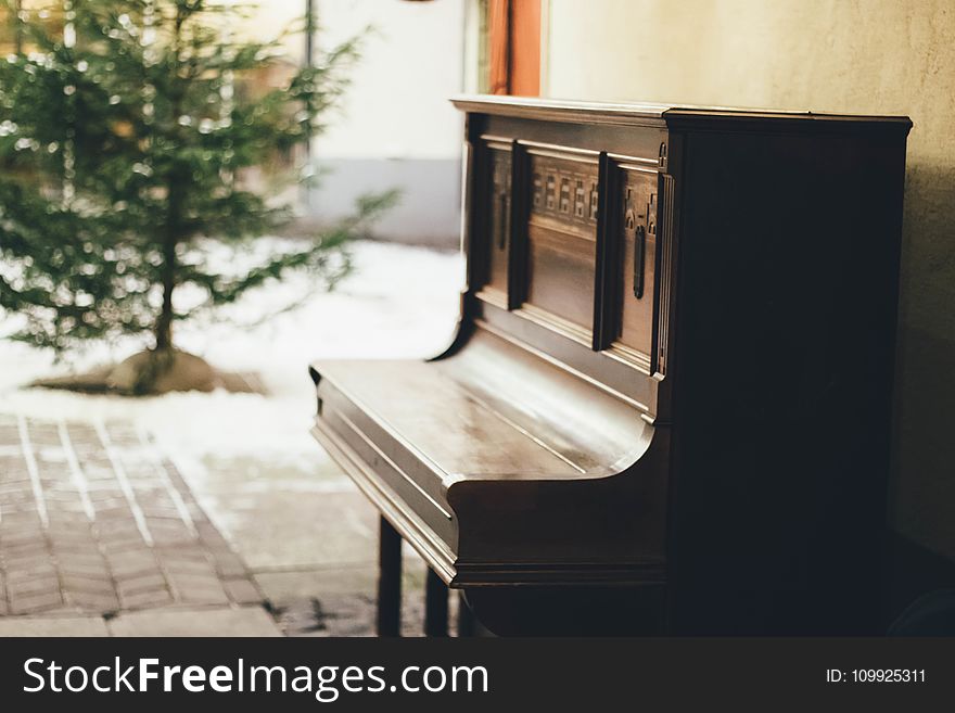 Brown Wooden Upright Piano In Shallow Focus Lens