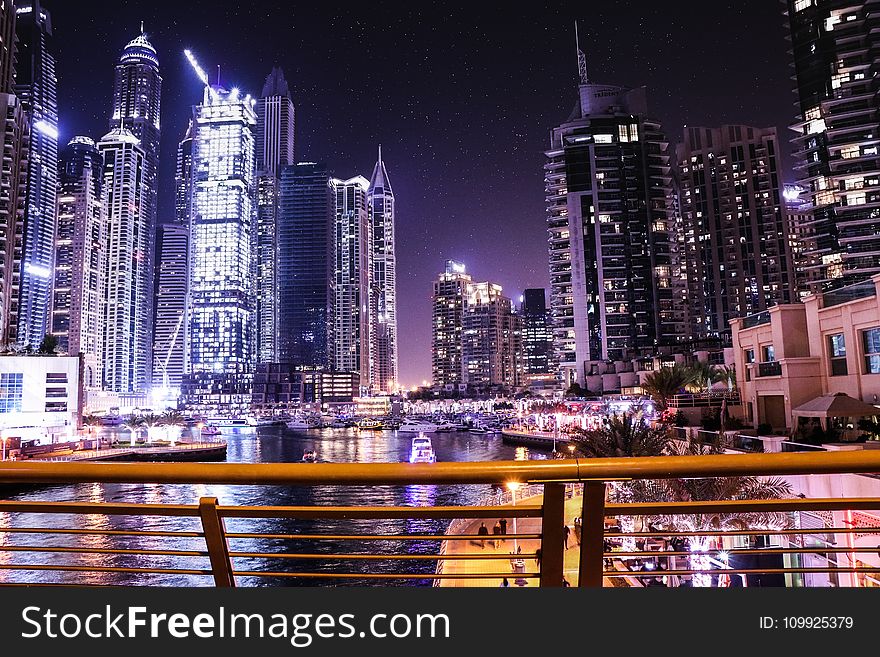 Boats on Body of Water Surrounded by High Rise Buildings