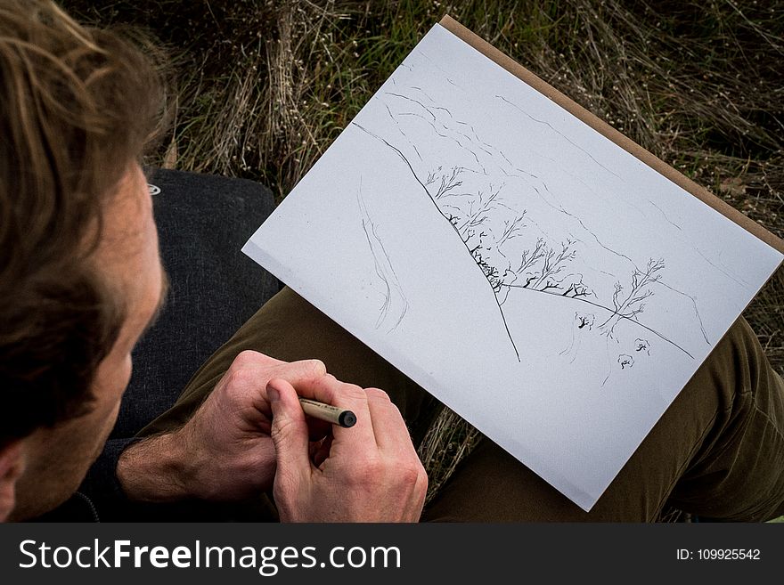 Man Drawing Mountain and Trees