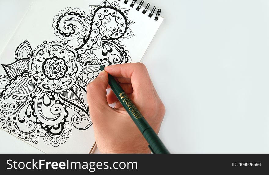 Person Holding Black Pen Sketching Flower