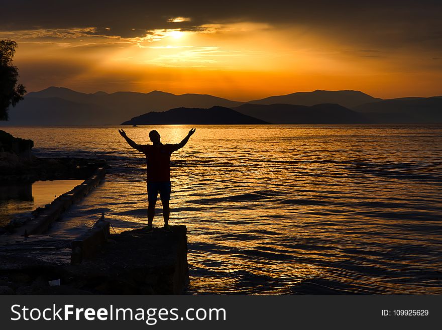 Silhouette Photo of Person Standing Near Beach
