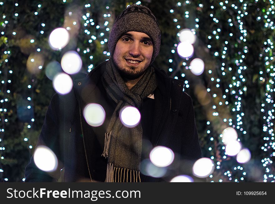 Man Wearing Snow Coat With Bokeh Light Background