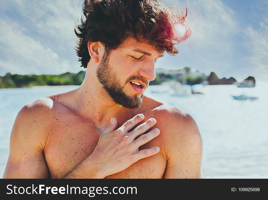 Topless Man in Front of Body of Water
