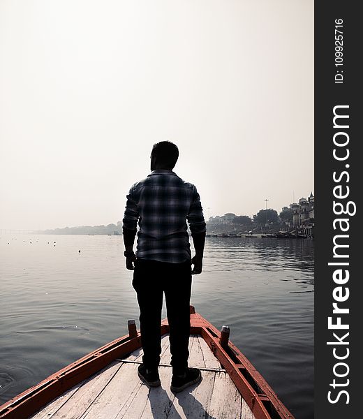 Man Standing On Wooden Boat