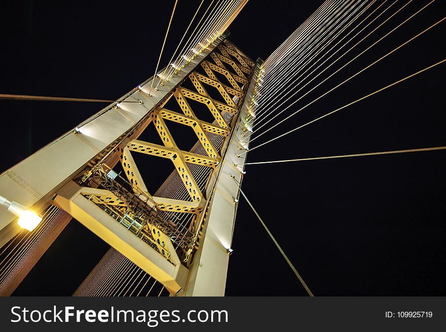 Low Angle Photography of White and Yellow Suspension Bridge at Nighttime