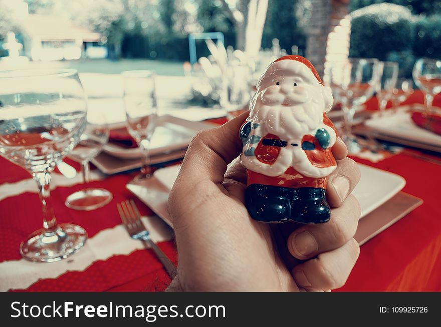 Person Holding Santa Claus Figurine