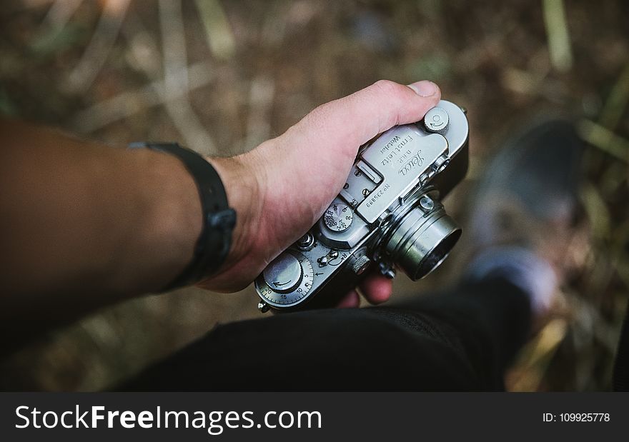 Person Holding Grey Point-and-shoot Camera
