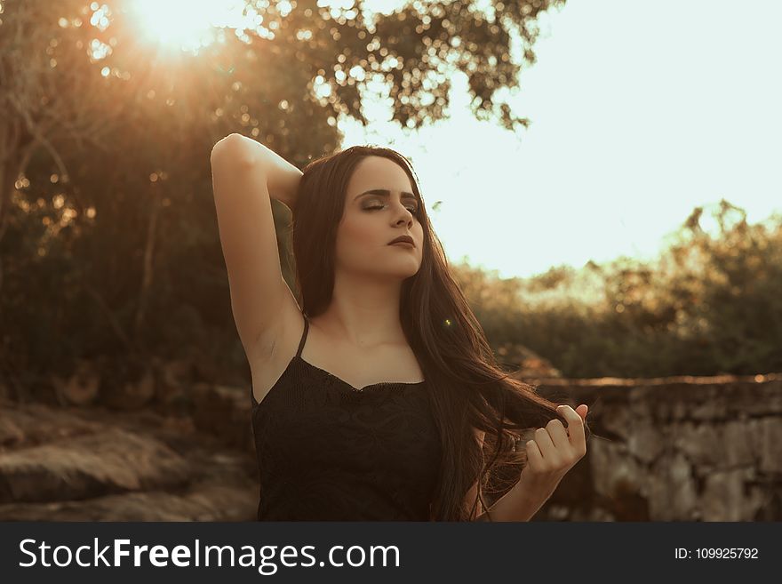 Woman Holding Her Hair Standing Near Tree