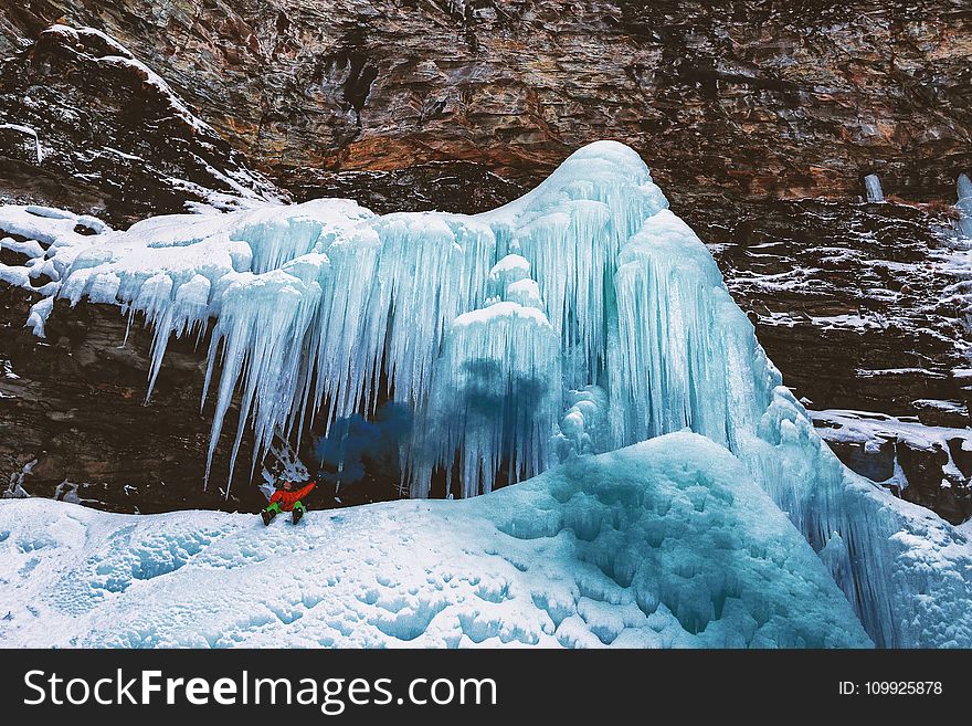 Person Sits on Mountain With Icicles