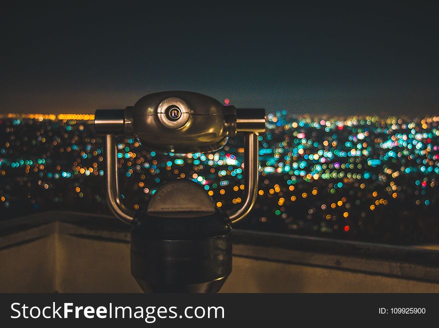 Black Binocular Facing Lighted City at Nighttime