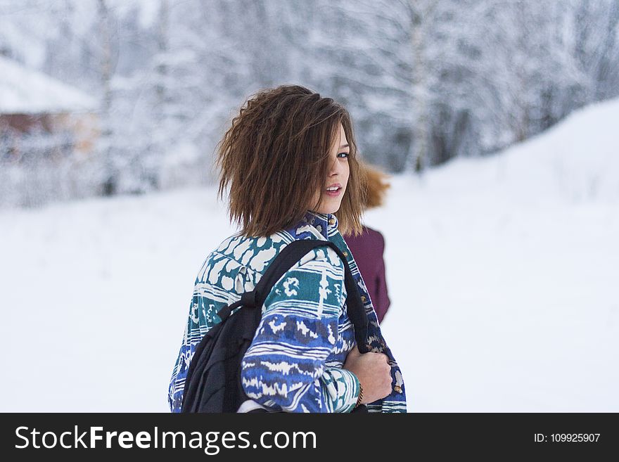 Selective Focus Portrait Photograph Of Woman Wearing Blue, Green, And White Tribal Jacket And Black Backpack Outfit