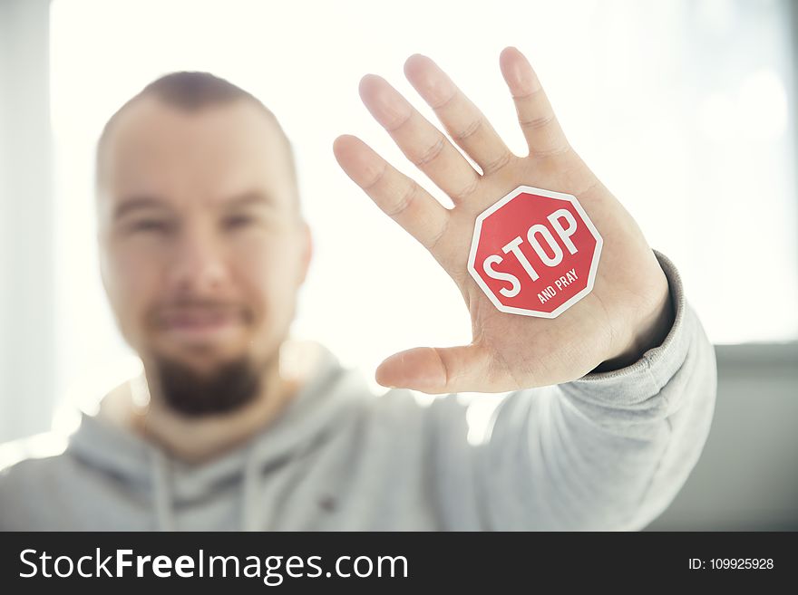 Photography of a Persons Hand With Stop Signage