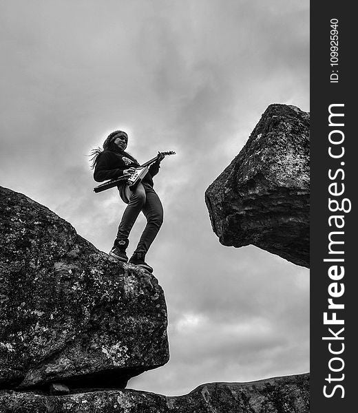 Woman Playing Electric Guitar On Top Of Rock Formation