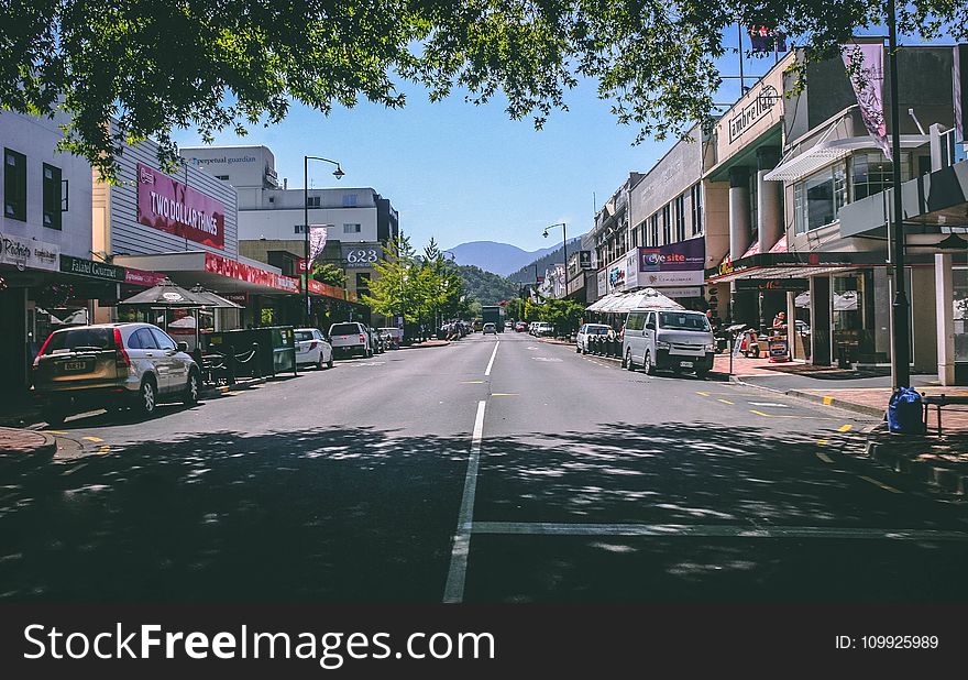 Photography Of Roadway With Parked Cars