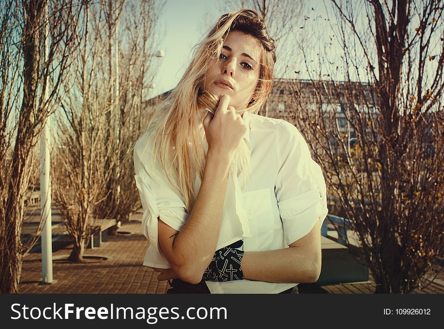 Blonde Woman in White Dress Shirt Beside Brown Plants