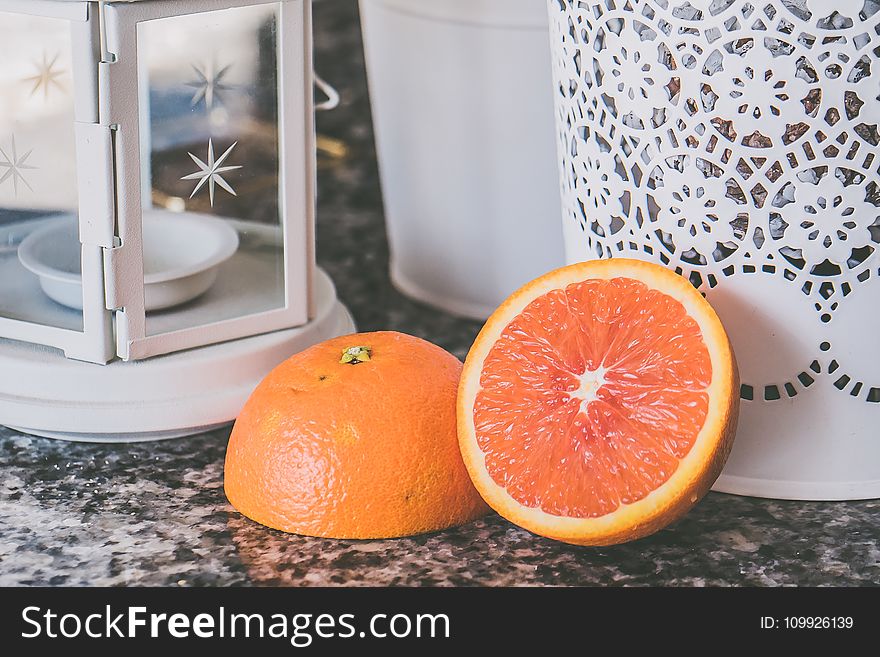 Sliced of Orange Fruit Near on White Framed Glass Candle Lantern
