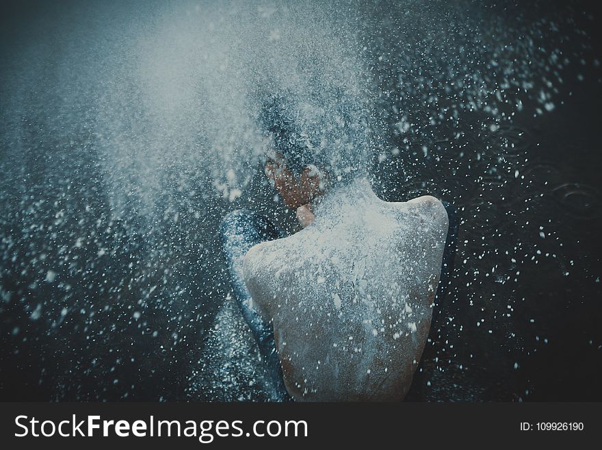 Topless Man Showering with White Powders