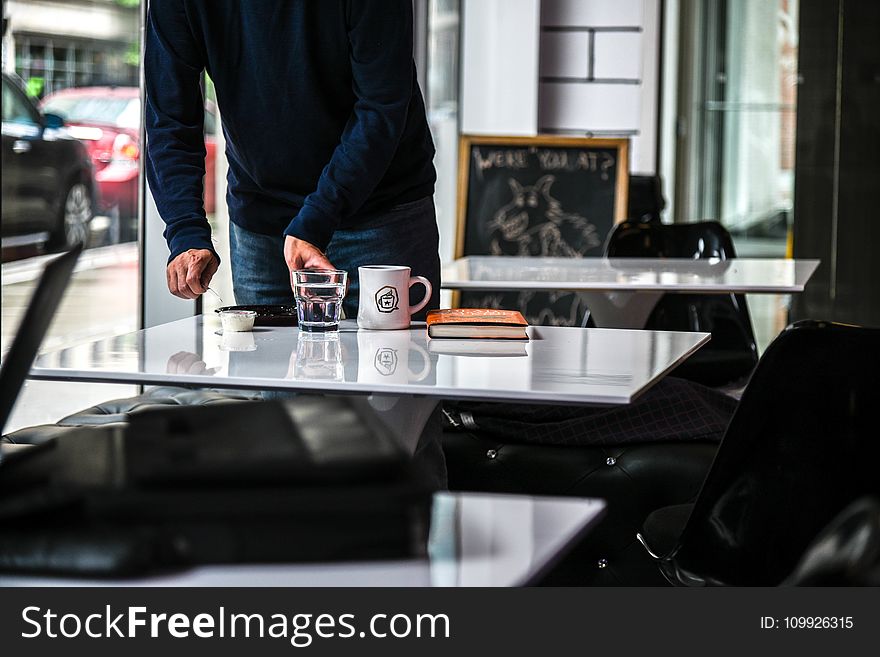 Person in Blue Long-sleeved Shirt Holding Clear Glass Cup