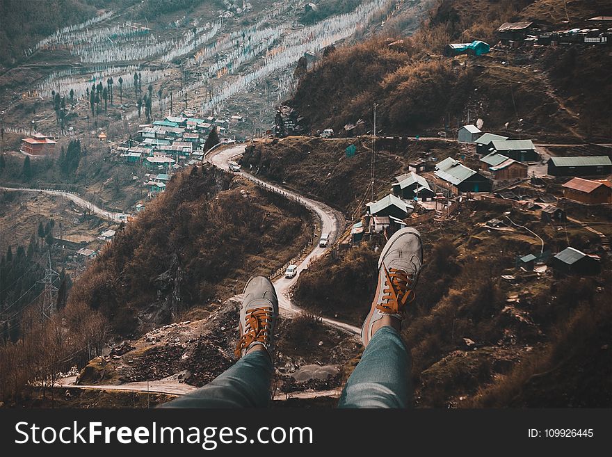 Person Wearing White Sneakers With Overlooking of Village on Hills