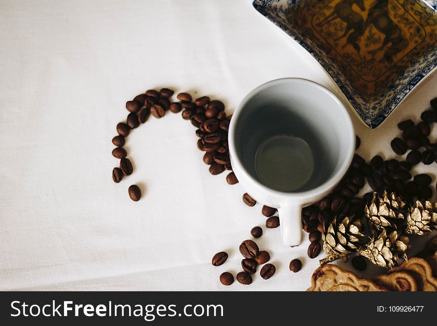 Brown Coffee Beans Near White Ceramic Mug
