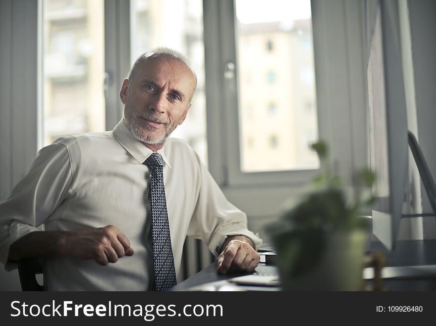 Man Sitting On Chair Beside Table