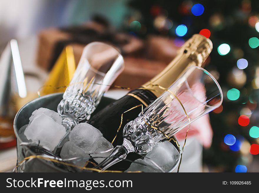 Selective Focus Photography of Brown Labeled Bottle and Two Clear Glass Champagne Flutes