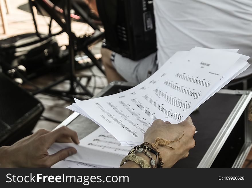 Person Holding White Musical Note Sheets