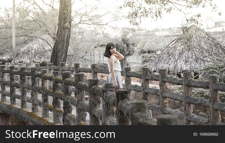 Woman Wearing White Sleeveless Dress Standing on Gray Wooden Dock