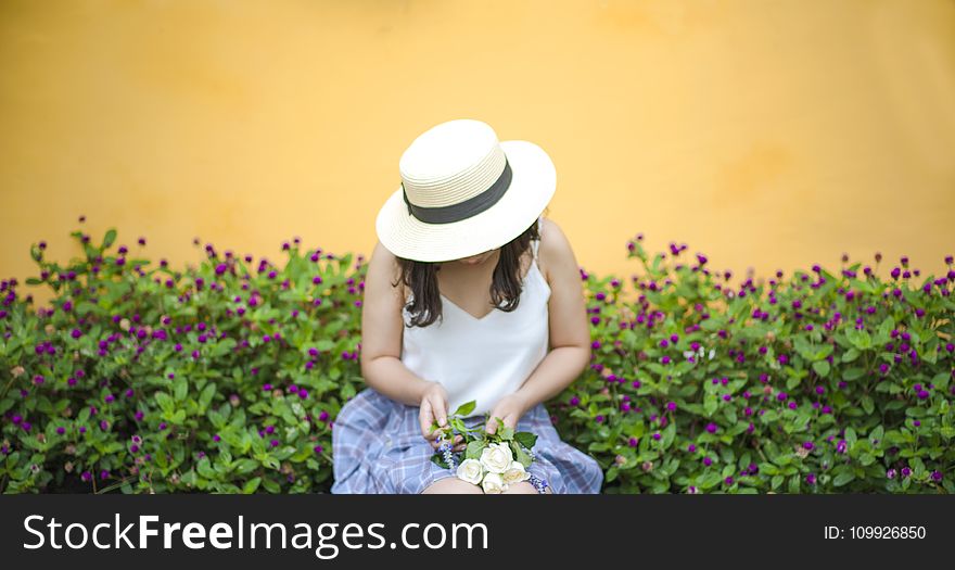 Woman Holding Bunch of White Roses While Sitting Near Flower Fields