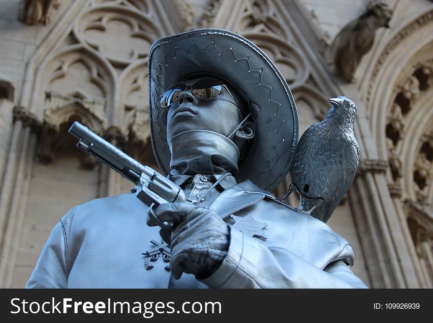 Selective Focus Photography of Cowboy Holding Revolver Pistol Statue