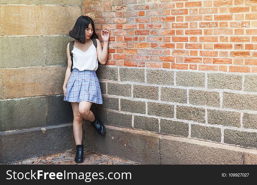 Woman Beside Brick and Cinder Wall