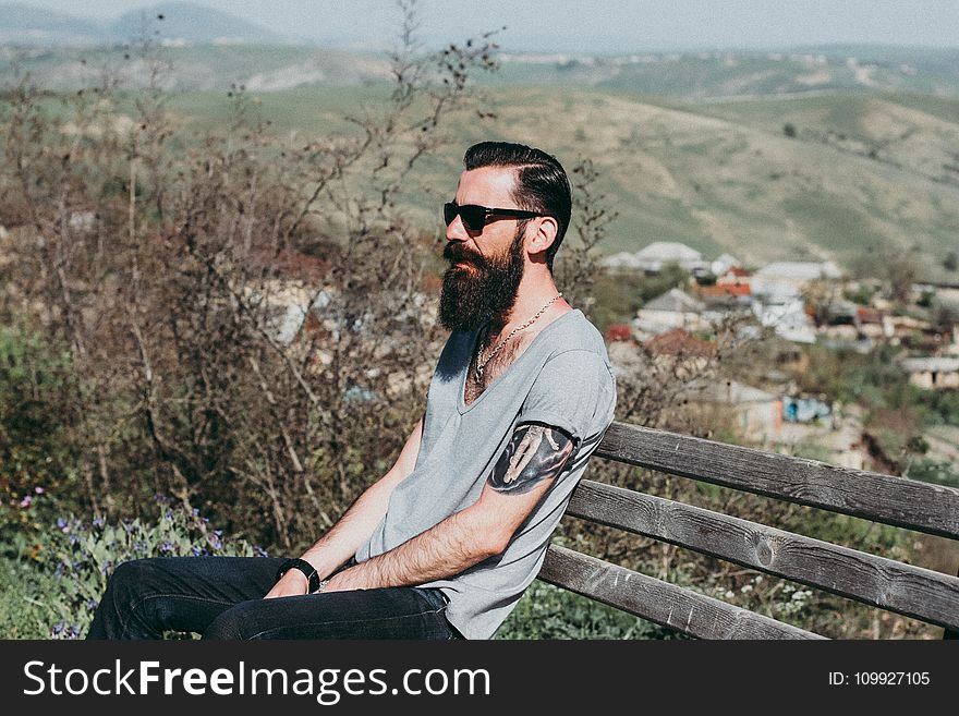 Photography of a Man Sitting on Wooden Bench