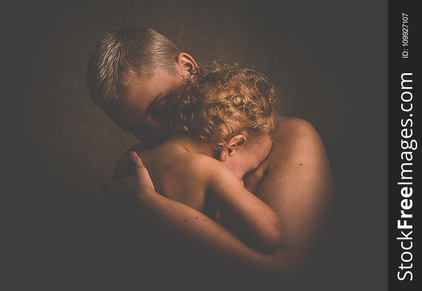 Photo of Topless Person Carrying Curly Haired Child