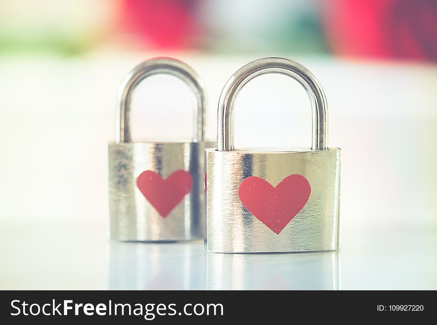 Bokeh Photo of Two Heart-printed Stainless Steel Padlocks