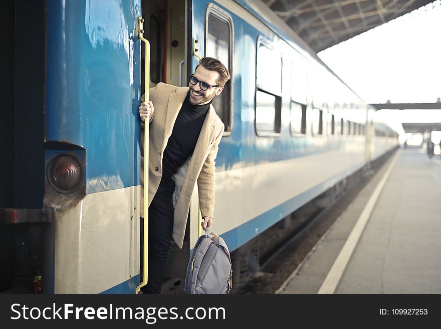 Man Wearing Beige Overcoat Inside Train