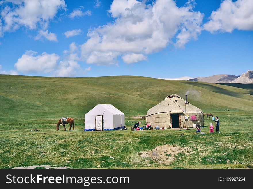 Photo of Hut And Tent On Grass Field