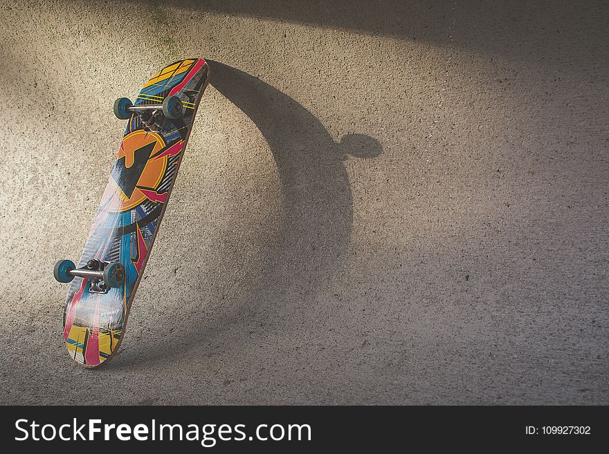 Multicolored Skateboard Leaning on Wall