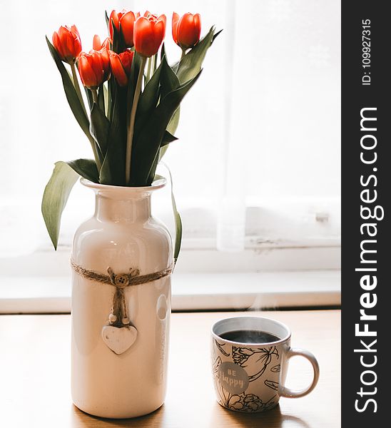 Red Tulips Flowers in White Ceramic Vase Beside Cup of Coffee