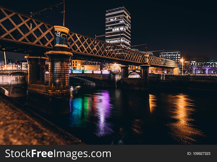 Architectural Photo of Brown Concrete Bridge and High Rise Building during Night Time