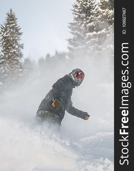 Person in Grey Jacket and Red Snow Goggles Riding on Snowboard
