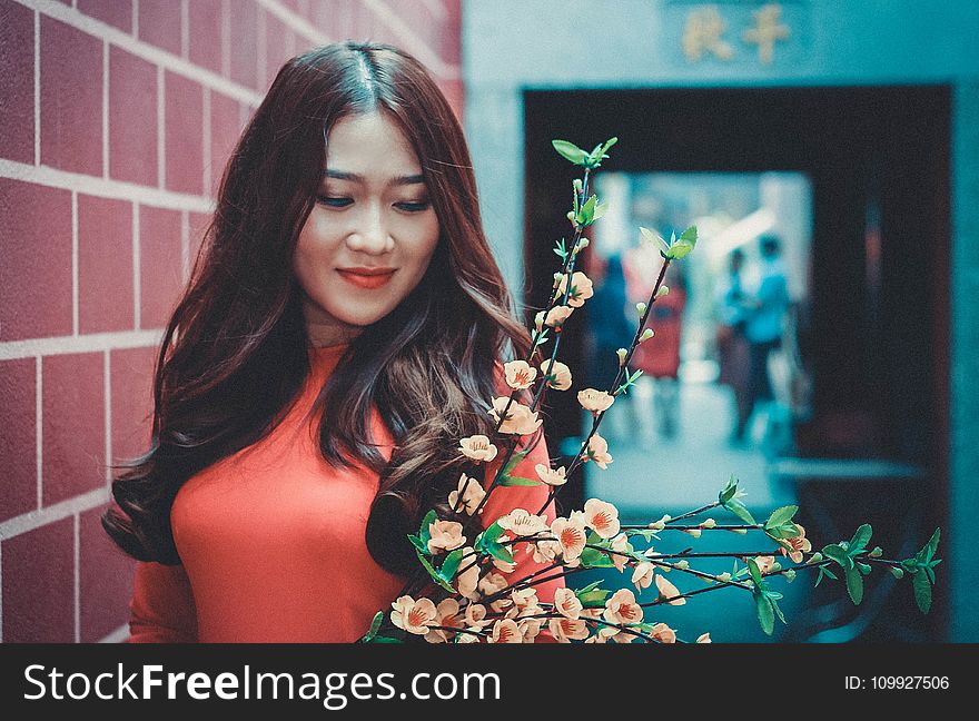 Woman Wearing Red Long-sleeved Shirt in Front of Flower